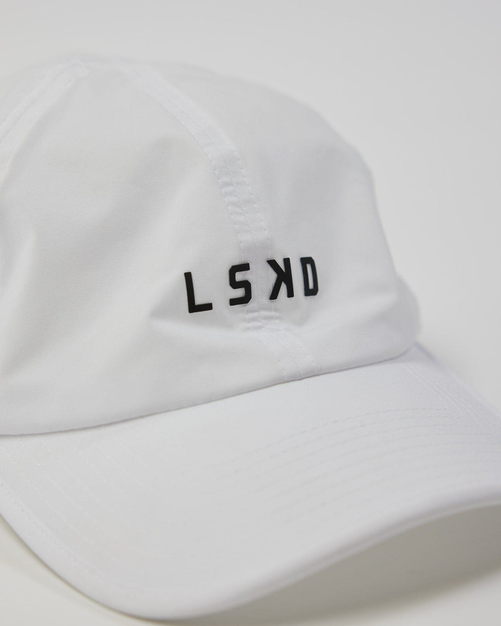 Model wearing Performance Tech Cap - White