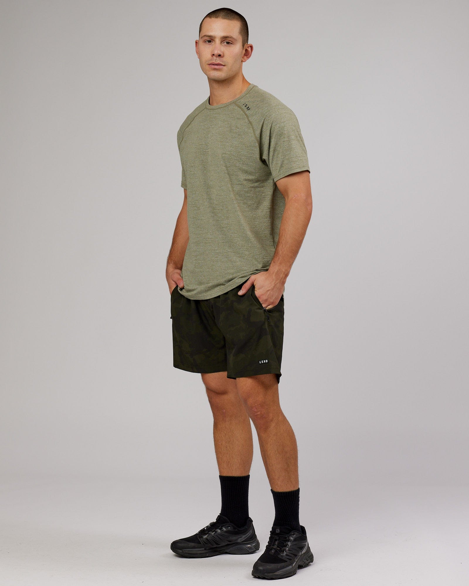 Model wearing Rep 7" Performance Short - Dark Olive Camo