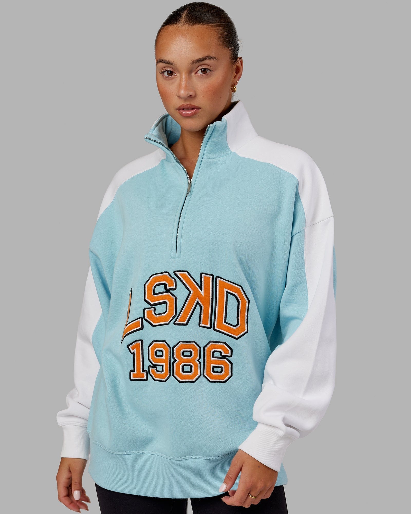 Model wearing Unisex Alumni 1/4 Zip Sweater Oversize - Crystal Blue-Orange Peel
