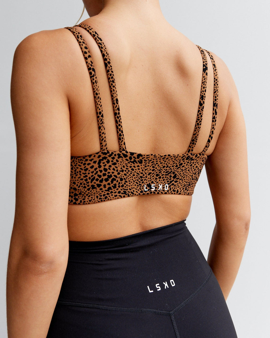 Model wearing Vogue Sports Bra - Agile Camel Print